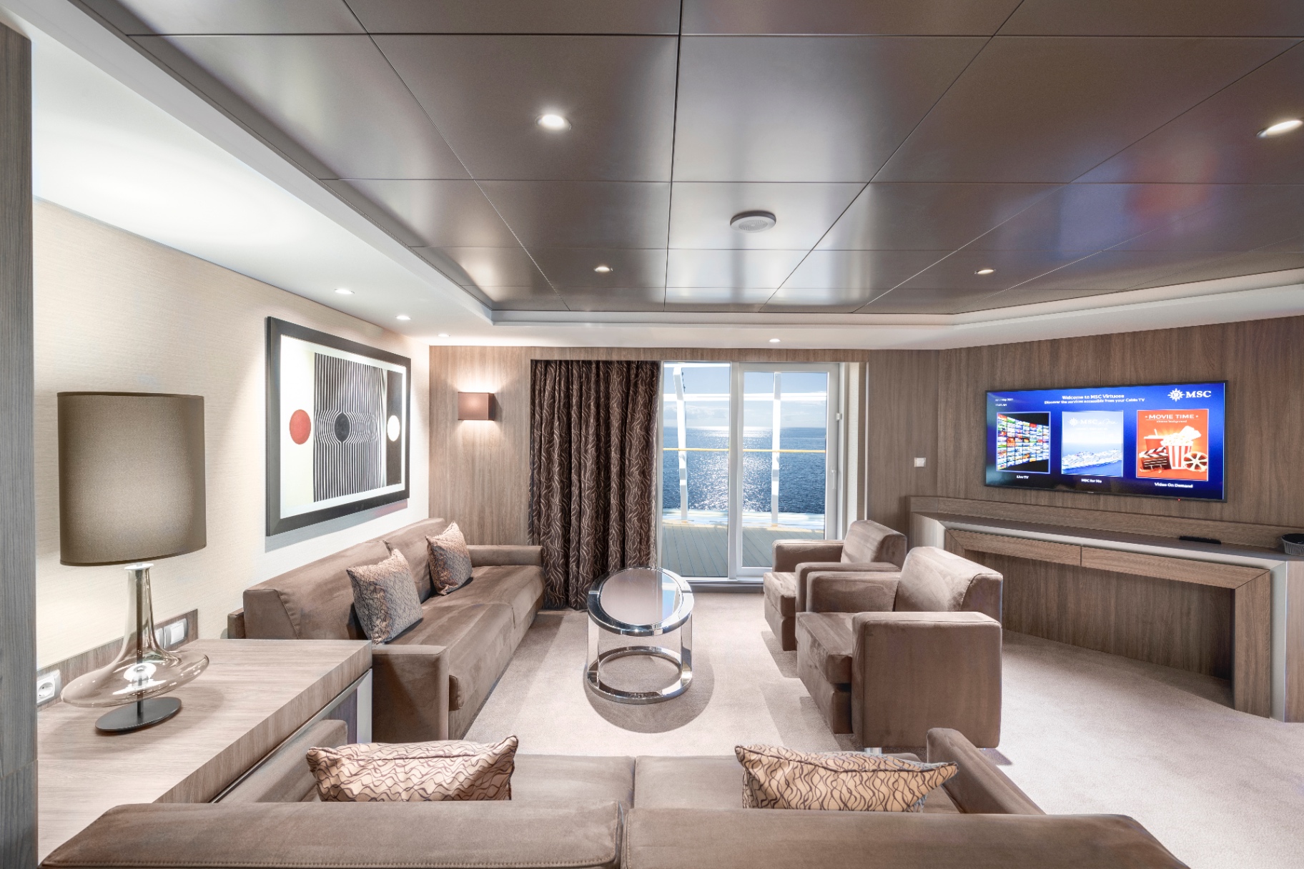 Salon d’une suite MSC Yacht Club ouvert sur un balcon privé face à la mer
